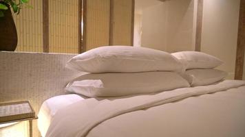 weiße Kissendekoration auf dem Bett im Schlafzimmer des Luxushotelresorts