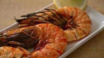 langostinos tigre a la parrilla o gambas con limón sobre tabla de madera video