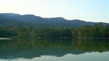 ang kaew-meer aan de universiteit van chiang mai met beboste bergen en schemerhemel video