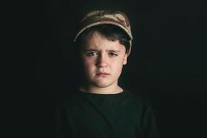 Sad boy on black background photo