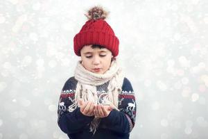 niño pequeño sopla nieve foto