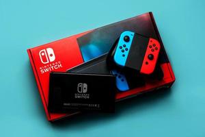 Nintendo Switch video game console box with Nintendo Switch logo, Back of Nintendo Switch and two Joy-Cons photo