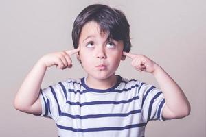 thoughtful child with his fingers on his head photo