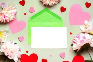 Greeting card. Green envelope and white paper with copy space, flowers and hearts. Congratulations on mother's day,birthday and Valentine's day
