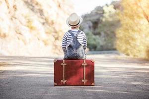 Boy with suitcase on the road photo