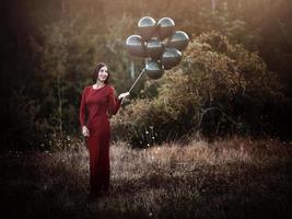 mujer sonriente con globos en el campo foto