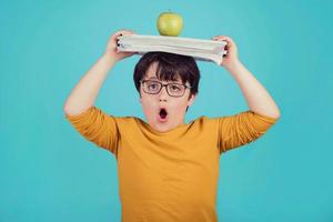 little boy with green apple and books photo