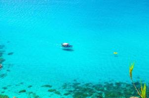 Fishing yacht and rubber boat in Capo Vaticano lagoon, Calabria, Italy photo