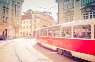 Typical old retro vintage tram on tracks near tram stop in the streets of Prague city photo