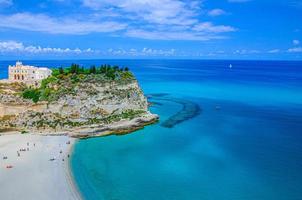 Monastery Sanctuary church Santa Maria dell Isola on top of rock of Tyrrhenian Sea and green trees photo