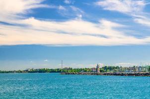 Garda Lake azure turquoise water surface with view of lighthouse on stone pier mole photo