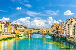 Ponte Vecchio stone bridge with colourful buildings houses over Arno River photo