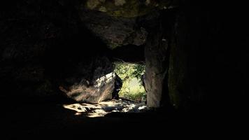 foto tirada de dentro de uma pequena caverna olhando para fora video