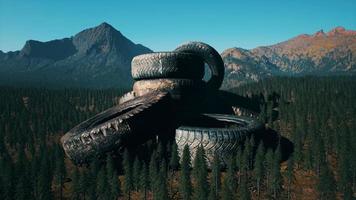 concept of environmental pollution with big old tires in mountain forest video