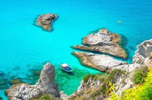 Fishing yacht and rubber boat in Capo Vaticano lagoon, Calabria, Italy photo