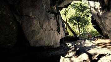 foto tirada de dentro de uma pequena caverna olhando para fora video