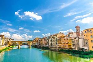 Ponte Vecchio stone bridge with colourful buildings houses over Arno River photo