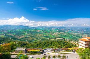 Aerial top panoramic view of landscape with valley, green hills, fields and villages of Republic San Marino photo