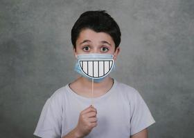 kid with medical and smile false on stick photo