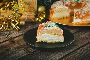 roscon de reyes con crema y adornos navideños. concepto del día de los reyes pastel de reyes magos español. pastel de epifanía español tradicional. postre típico español para navidad. enfoque selectivo foto