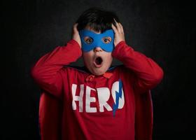 surprised child playing superhero photo