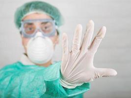 Stop coronavirus.Medical worker doctor showing a stop sign, background blur photo