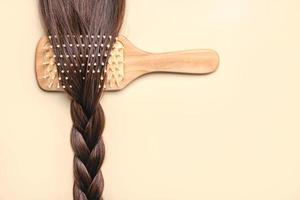 hairbrush with female brown hair braid.Hairdresser salon and hairstyles concept photo