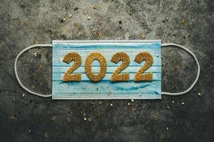 New Years Eve celebration concept background.Medical mask with the numbers 2022. Covid-19 New Year concept photo