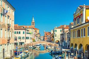 paisaje urbano de chioggia con estrecho canal de agua vena con barcos multicolores amarrados foto