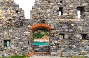 Ruins of brick stone old medieval wall with windows and door arch in Portovenere town photo