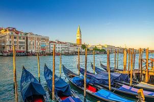 Gondolas moored in water of Grand Canal waterway in Venice photo