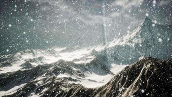 Starker Schneefall, konzentriert auf die Schneeflocken, Berge im Hintergrund video