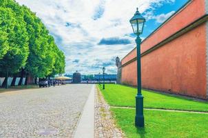 Fortress brick wall, Street light and green trees in Peter and Paul Fortress