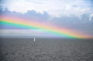 Small white sailing yacht and rainbow in Gulf of Finland, Baltic sea photo