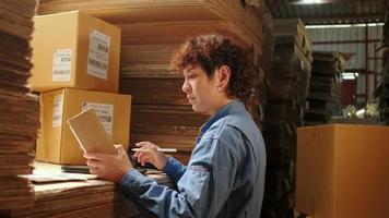 One female worker in safety uniform using bar code scanner to check shipping orders at parcels warehouse, paper manufacture factory for the packing industry, logistic transport service. video