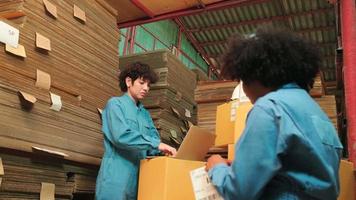två kvinnliga säkerhetsuniformer och kollegor använder streckkodsläsare för att kontrollera försändelseorderlager på paketlager, papperstillverkningsfabrik för förpackningsindustrin, logistisk transporttjänst. video