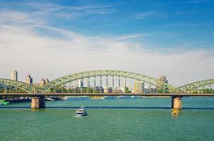 The Hohenzollern Bridge or Hohenzollernbrucke across Rhine river with tourist boat photo