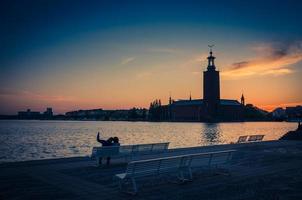 Silhouette of man and woman sitting on bench, Stockholm, Sweden photo