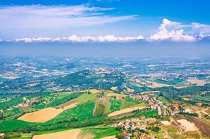 Aerial top panoramic view of landscape with valley, green hills, fields and villages of Republic San Marino photo