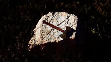 hache de guerre pour viking sur le rocher au coucher du soleil