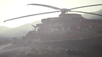 velho helicóptero militar enferrujado no deserto ao pôr do sol video