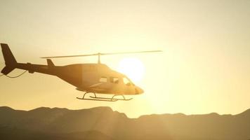 Helicóptero volador en cámara lenta extrema de 8k y cielo al atardecer video