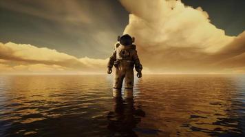 Spaceman in the sea under clouds at sunset video