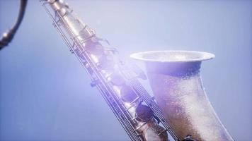 saxofón tenor dorado sobre fondo azul con luz video