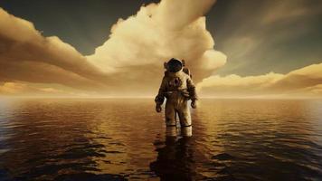 Spaceman in the sea under clouds at sunset video