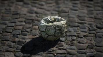 Old soccer ball in the pavement yard video