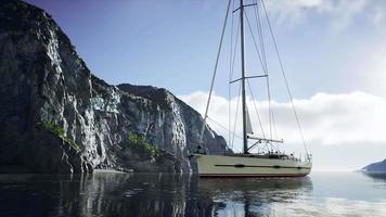 yacht dans la mer avec une île rocheuse verdoyante video