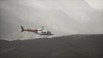 Helicóptero volador en cámara lenta extrema cerca de montañas con niebla video