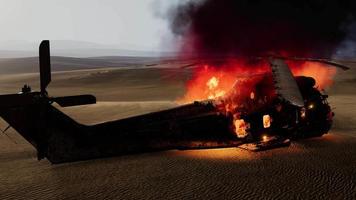 Hélicoptère militaire brûlé dans le désert au coucher du soleil video