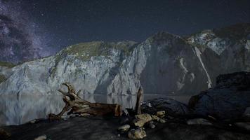 hyperlapse of night starry sky with mountain and ocean beach in Lofoten Norway